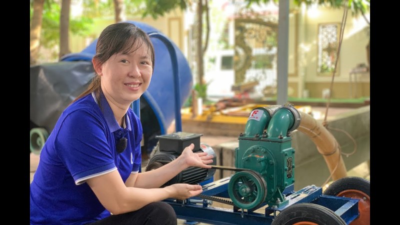 Ảnh bìa clip máy bơm bùn FarmX xử lý bùn ao biogas, nhân viên xưởng ngồi bên đầu bơm màu xanh lắp trên xe đẩy